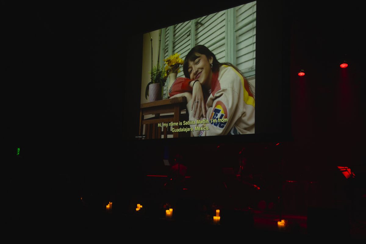 Documentary interview projected above the stage